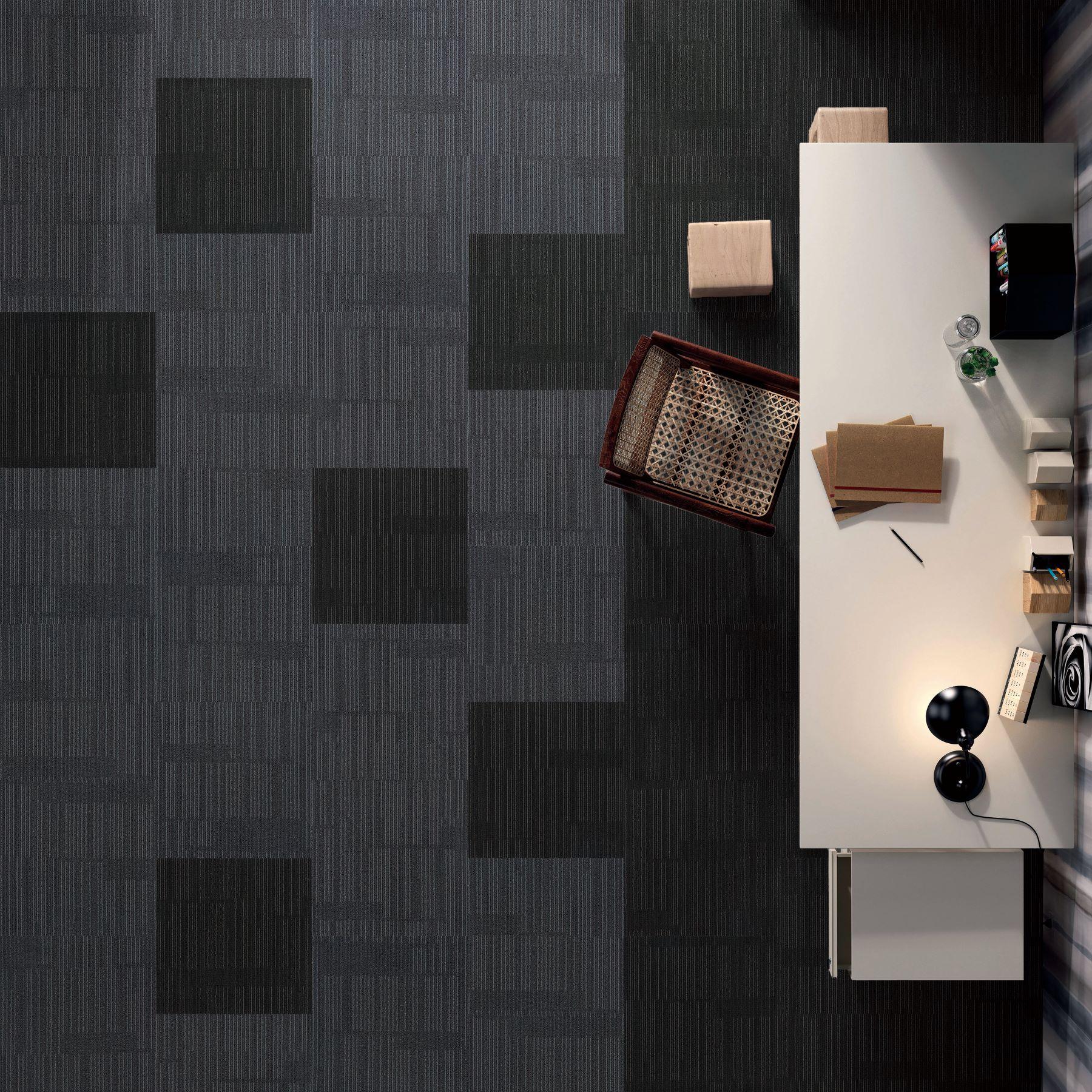 Top-down view of a modern office setup with a desk and office items on a dark textured wall.